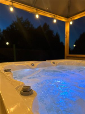 the hot tub at night light up with lights from within the tub an above
